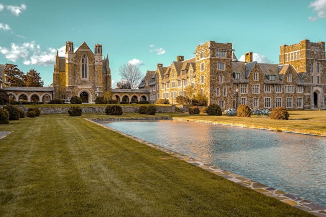 College campus and brick buildings with grassy lawn and reflection pool