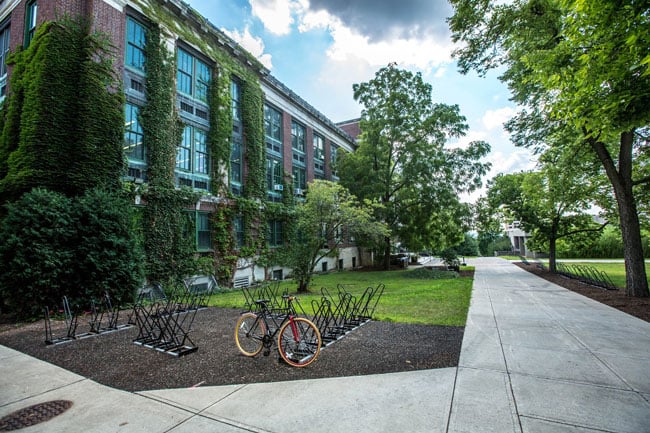 A college campus with ivy growing on buildings and rows of bike racks