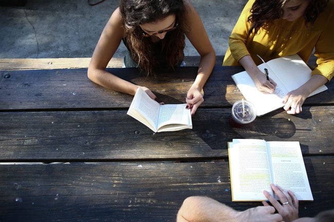 Students sit at a table studying