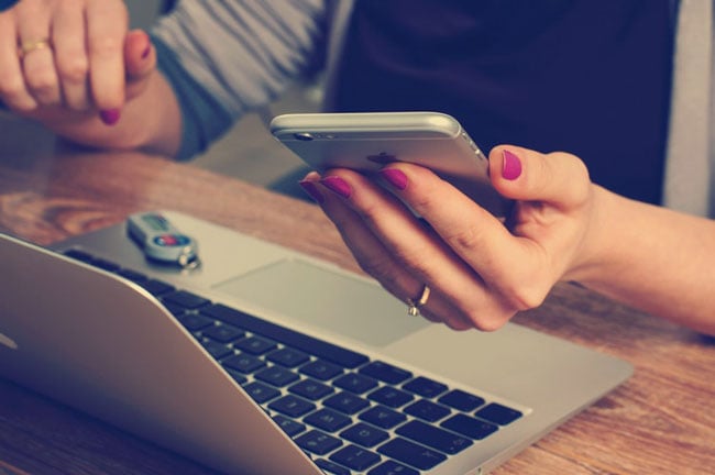 woman using a laptop and smartphone