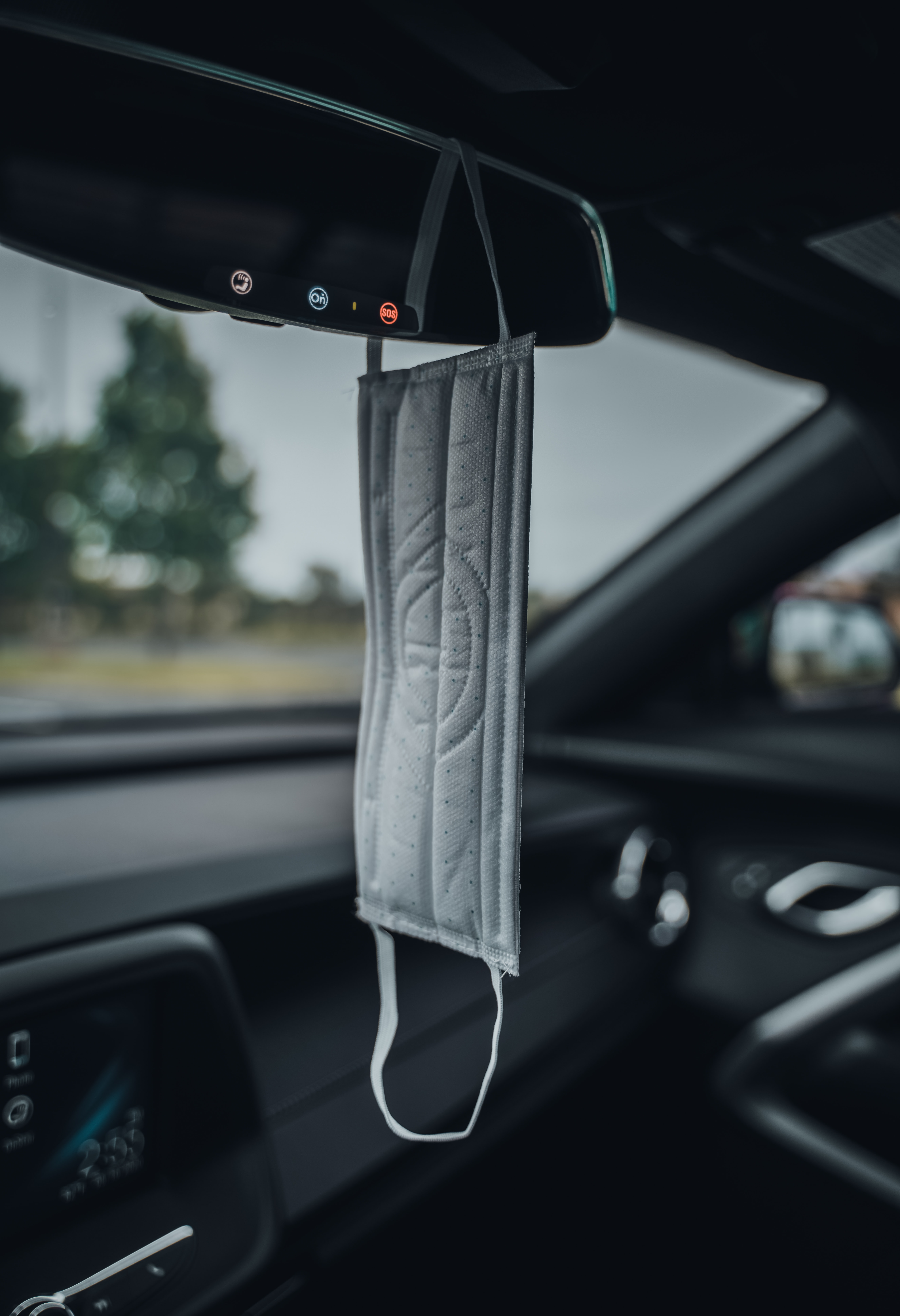 face mask hanging from car rearview mirror