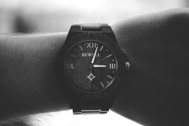 a man looks at the time on his wristwatch