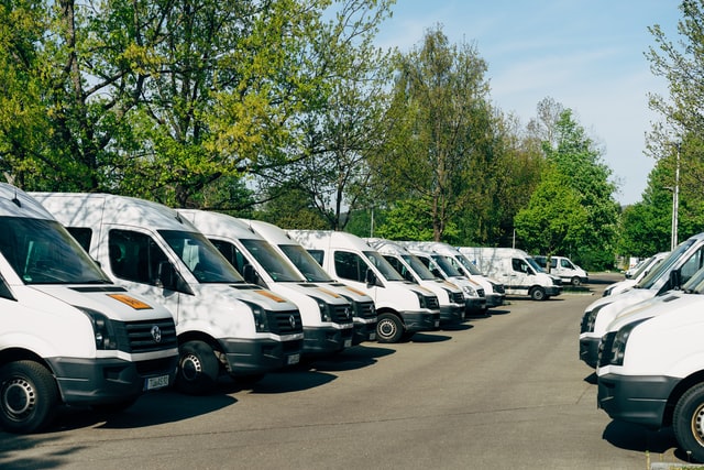 White delivery vans parked in a lot.