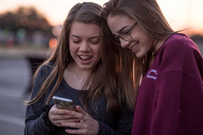 two students use a smartphone