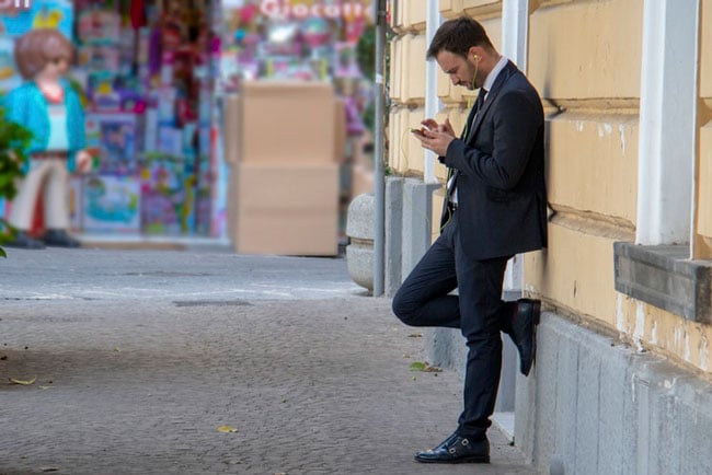man standing and sending a text