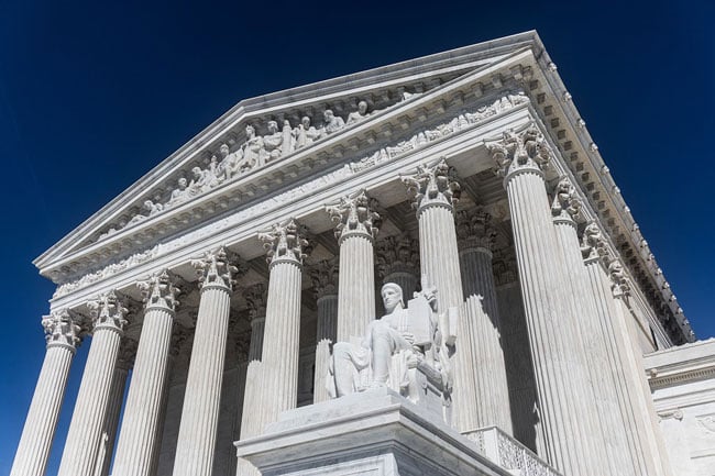 a courthouse looms against a blue sky