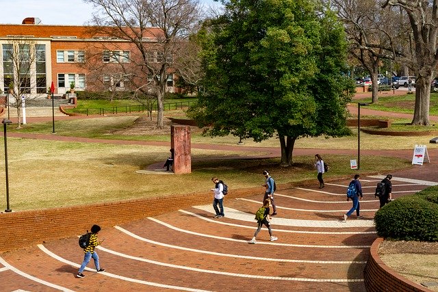 students practicing social distancing walking on a college campus