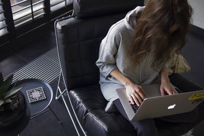 woman sitting in desk chair on a computer